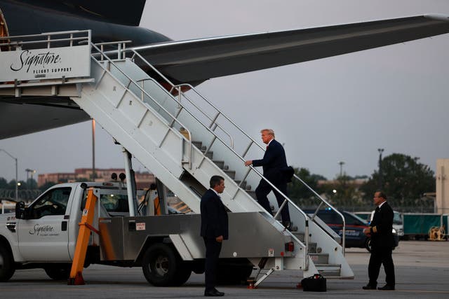 <p>Donald Trump boards his plane in Atlanta following his arrest at Fulton County jail</p>